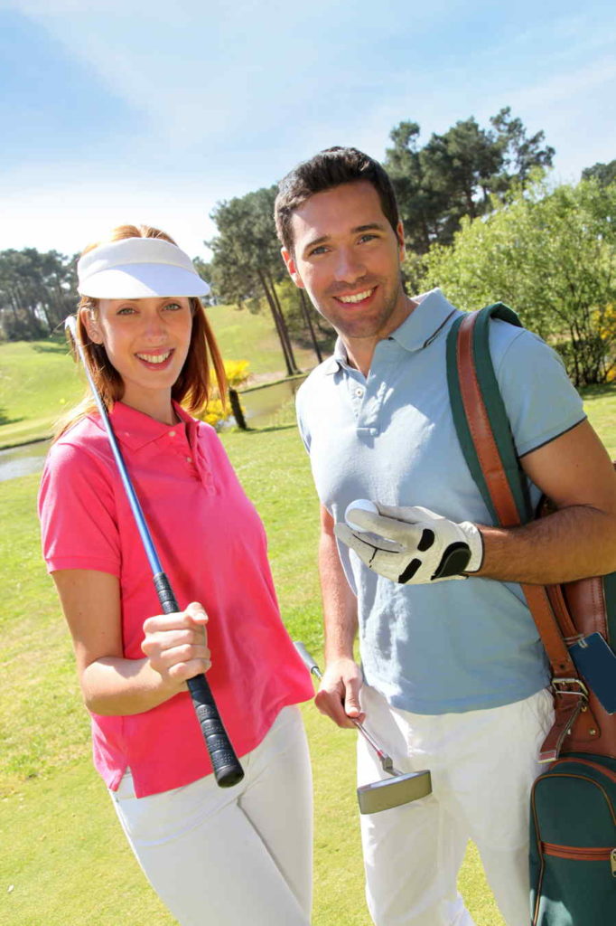Man and women golfers holding their golf clubs